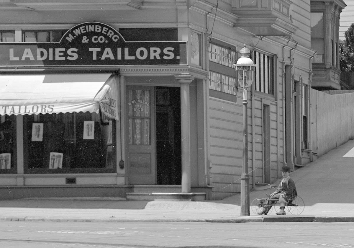 Kid on wagon beneath gas street lamp